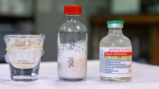 From left to right, we see a beaker containing snake venom, a vial of freeze-dried venom, and a vial of antivenom.